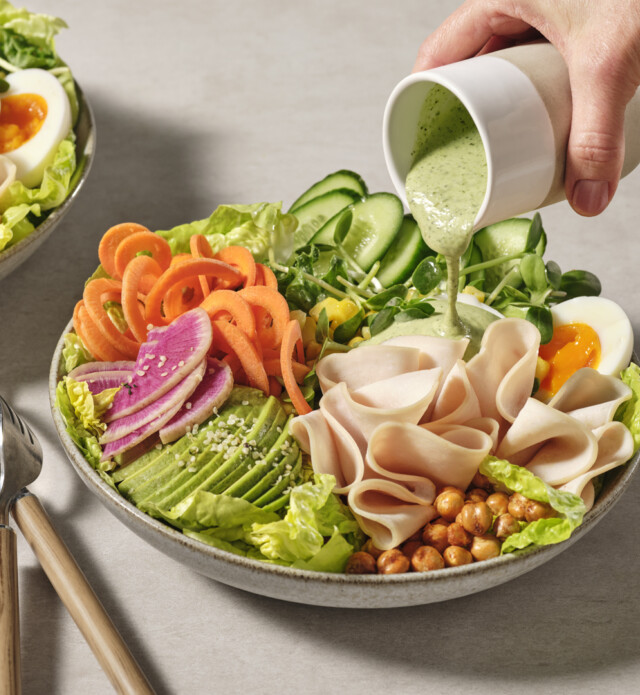 Close-up of dressing being poured on a salad