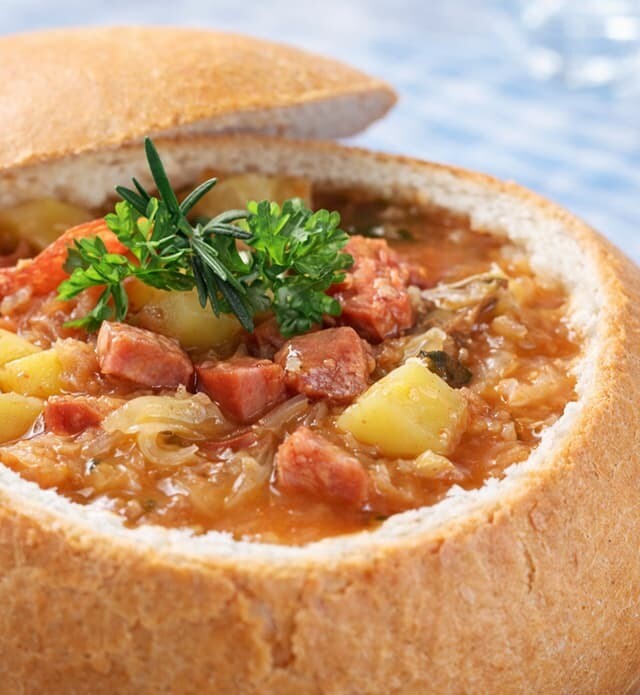 A close-up of a bread bowl filled with goulash.