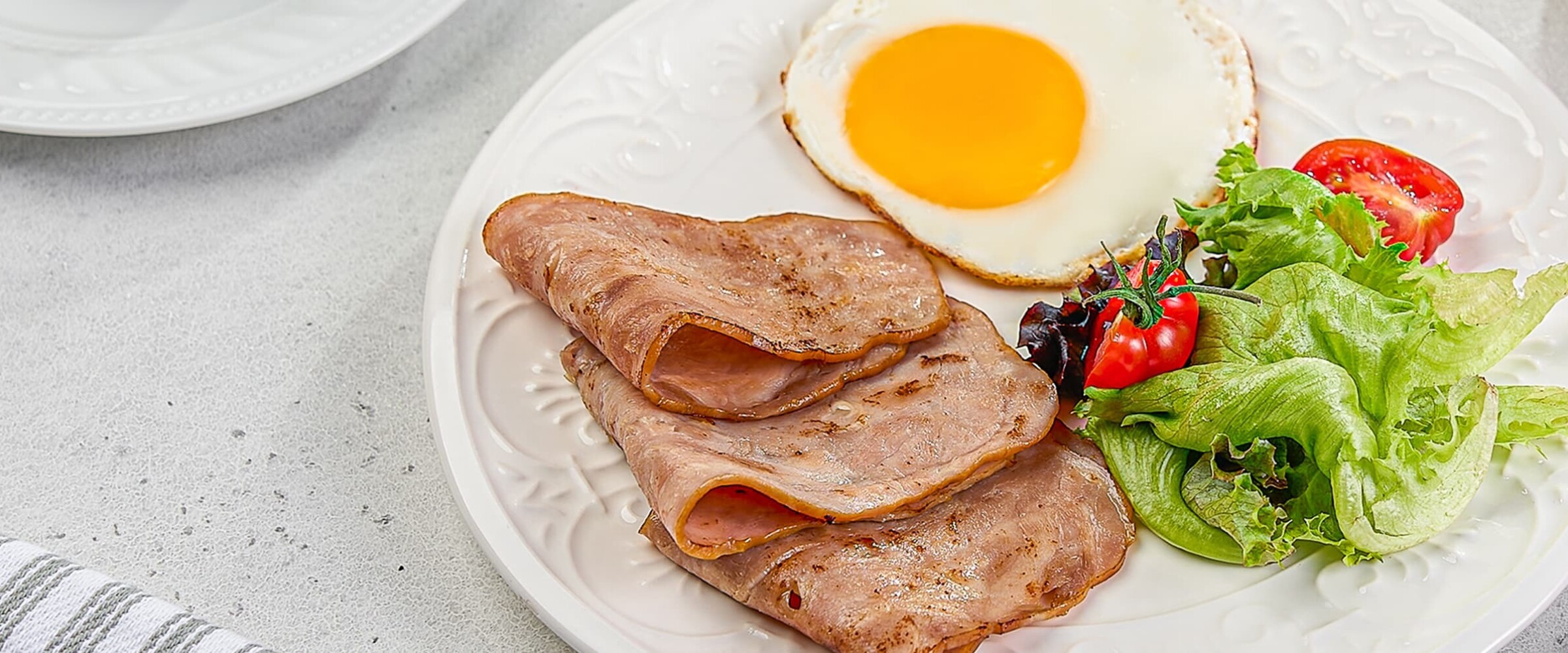 Close-up of a plate of turkey slices, eggs and a salad.