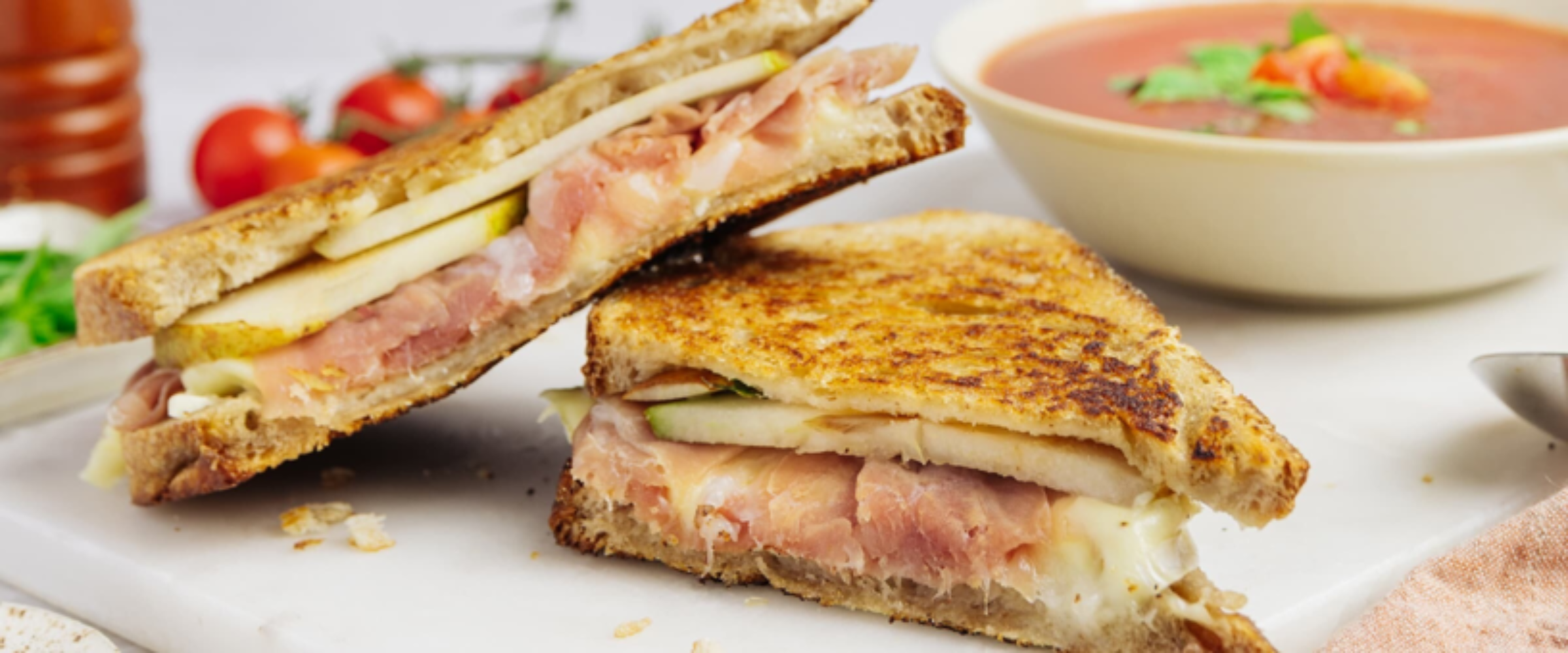 Close-up of a sandwich filled with sliced meat and vegetables.